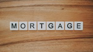 Tiles spelling mortgage on a wooden surface, symbolising housing loans and property finance concepts
